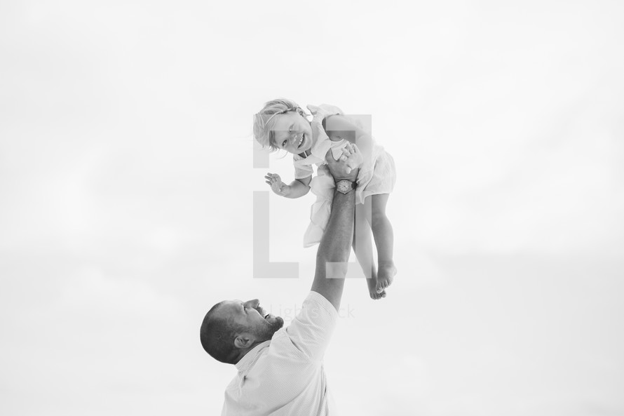 father lifting up his daughter 