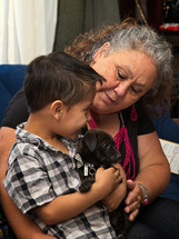 boy and grandmother petting a dog 