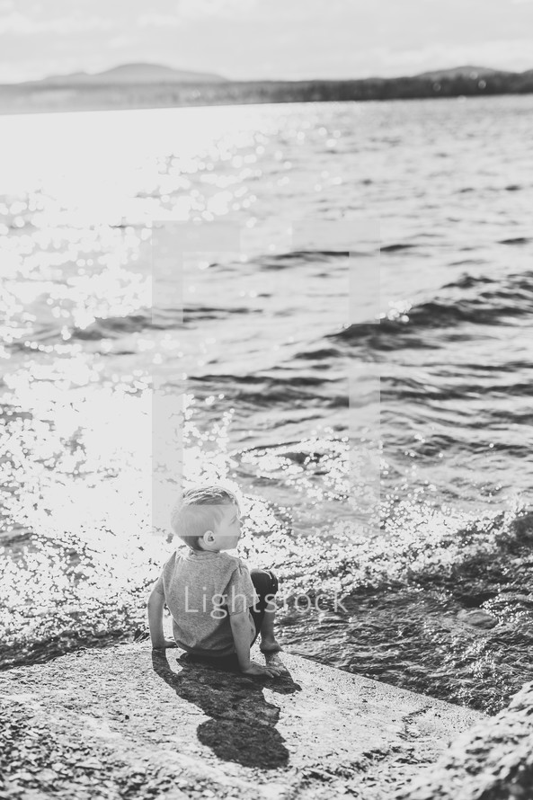 a child sitting on a shore 
