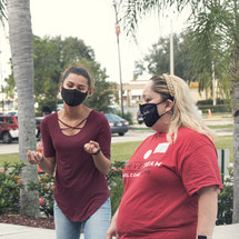 women standing in front of a church wearing masks 