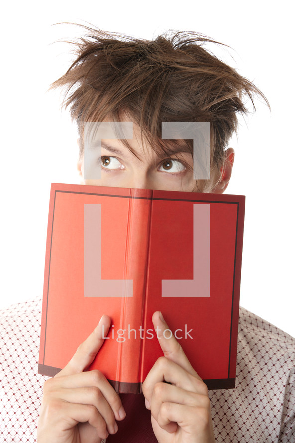 a man peeking from behind a book 