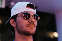 a man in sunglasses and backwards ball cap 