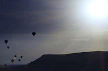 silhouettes of hot air balloons in the sky 