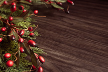 Christmas garland with berries and wood background
