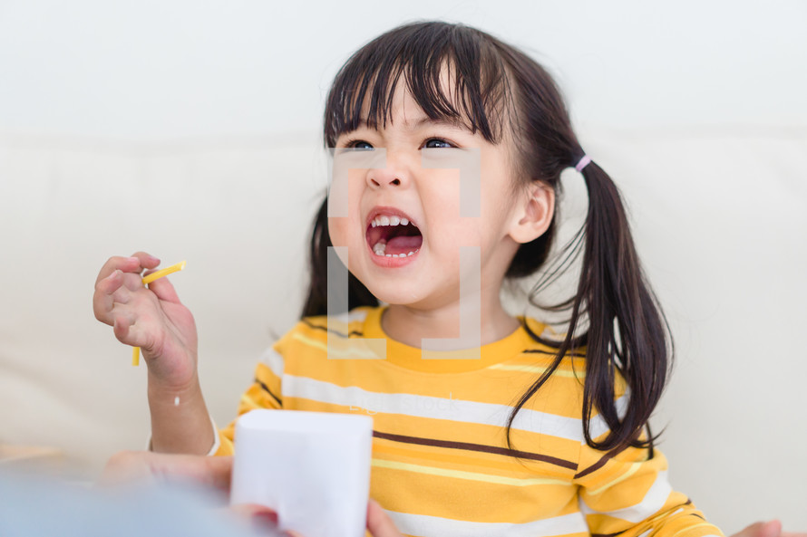 toddler girl eating a snack 