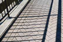 Shadows on the ground of a cobblestone footpath