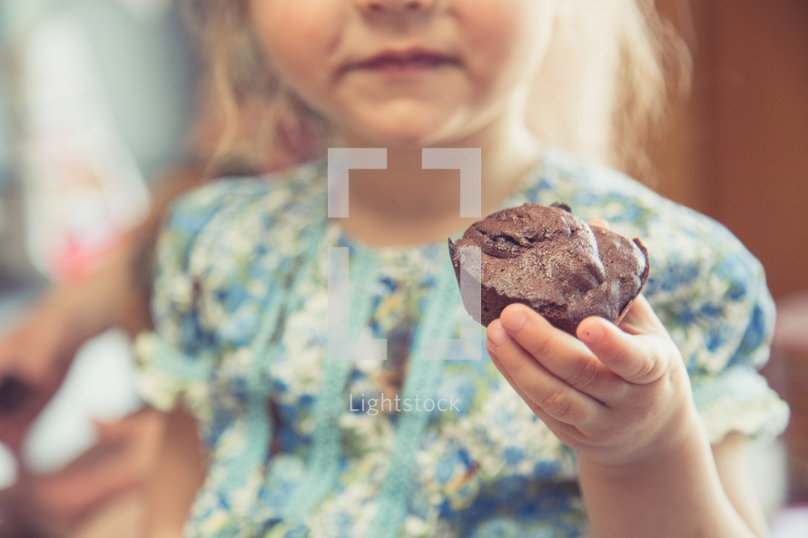 toddler girl eating a muffin 