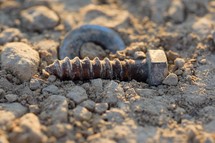 an old screw in dirt 