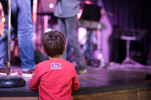 a child watching musicians perform on stage 