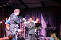 musicians performing on stage and a child on stage 