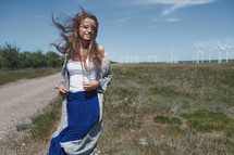 a woman standing in front of wind turbines 
