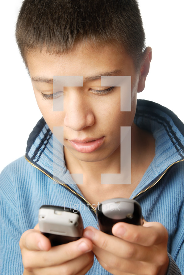 a boy holding two cellphones