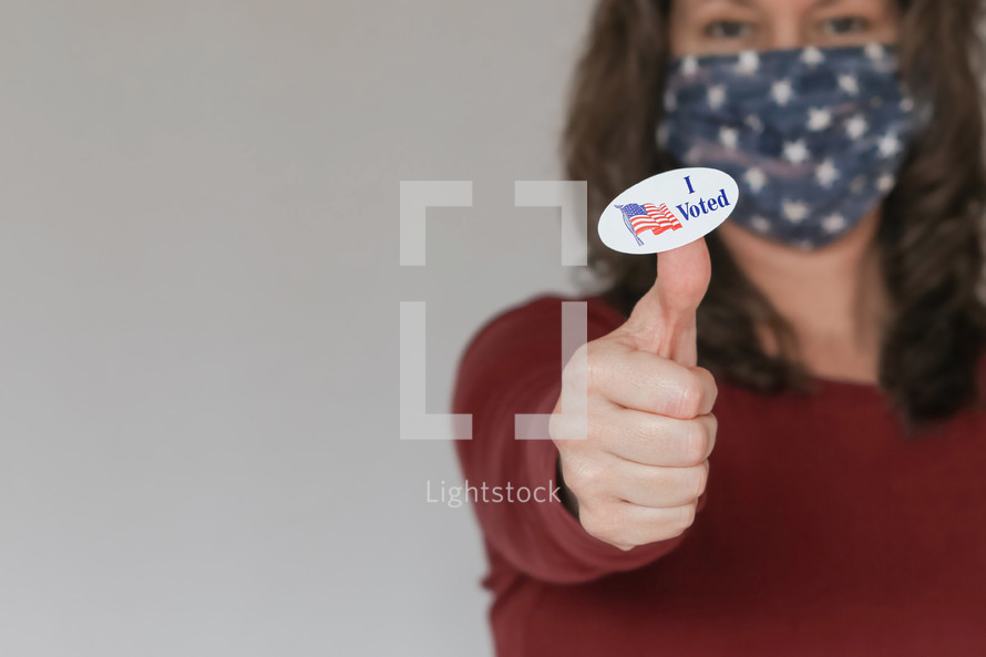 woman with an I voted sticker wearing a mask 