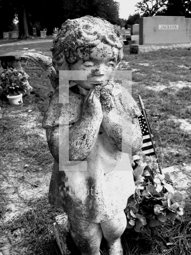 praying angel statue in a cemetery 