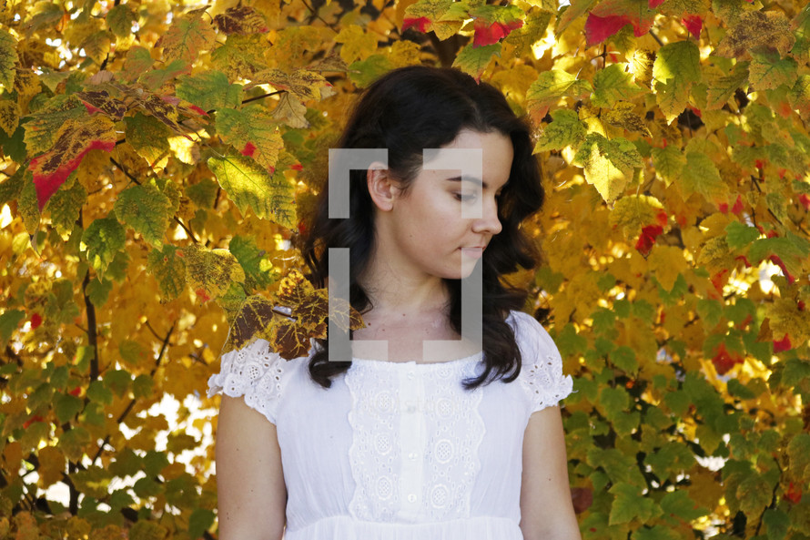 woman surrounded by fall leaves 