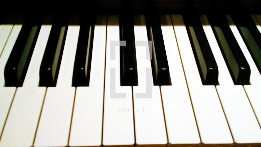 The Ivory black and white keys of a piano from the angle of a piano player or pianist.