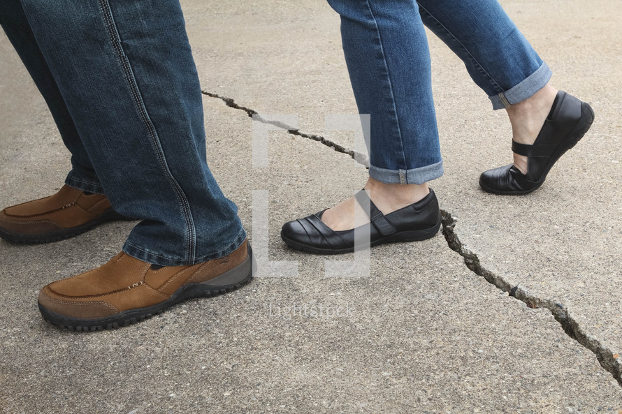 Wife stepping over a crack towards her husband