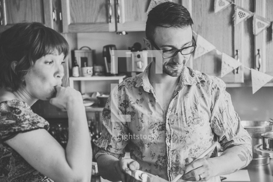 husband and wife baking together in the kitchen 