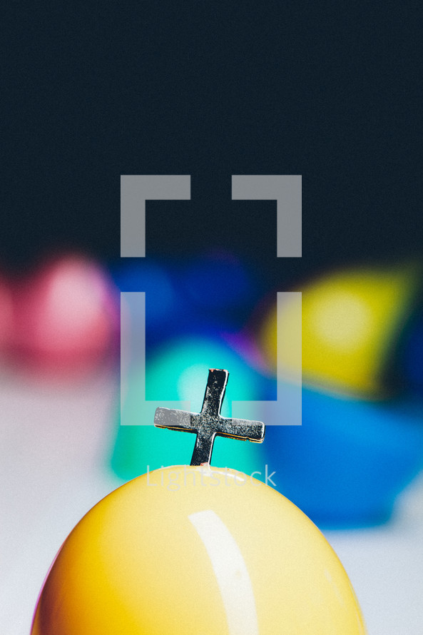Cross emerging from a plastic Easter egg.