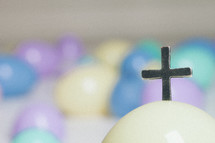 Cross protrouding from a plastic Easter egg.