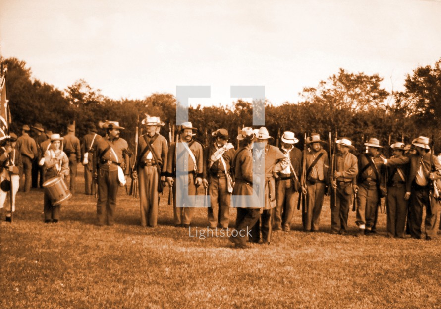 A lineup of Confederate Army Soldiers getting ready for inspection and a civil war re-enactment to illustrate history in the making for all to see and remember. 