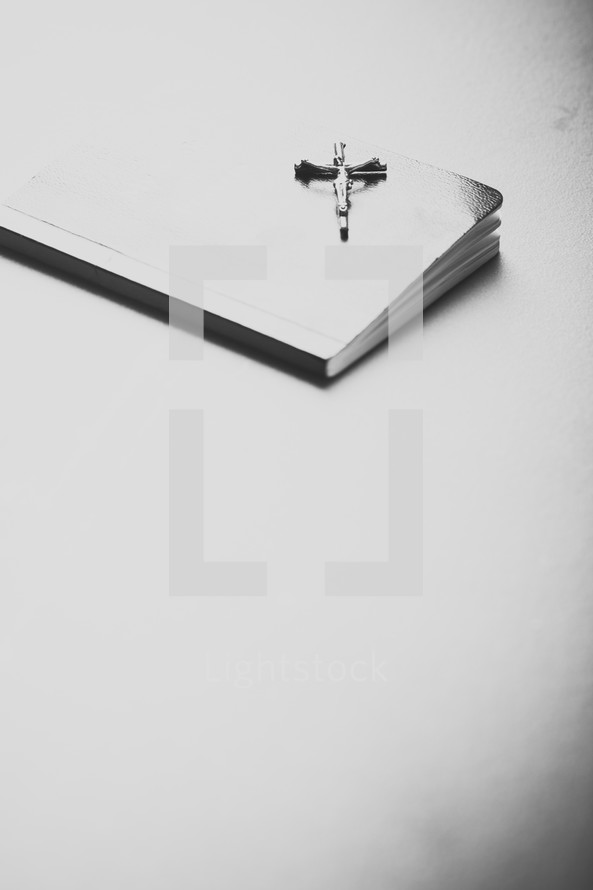 Silver crucifix on top of prayer book.