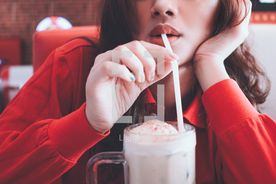 a woman drinking a milkshake 