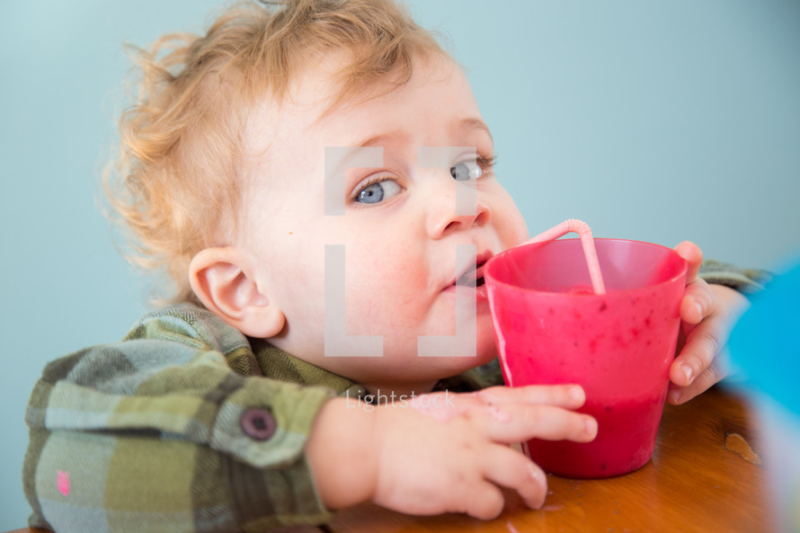 toddler boy drinking out of a straw 