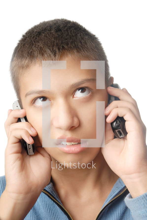 a boy talking on two cellphones 
