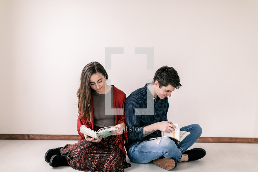 a couple sitting on the floor reading Bible 