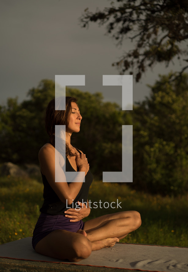 a woman outdoors doing yoga 