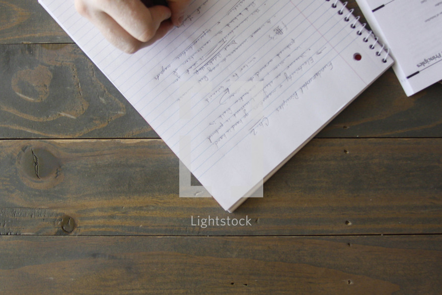 writing on a spiral notebook 