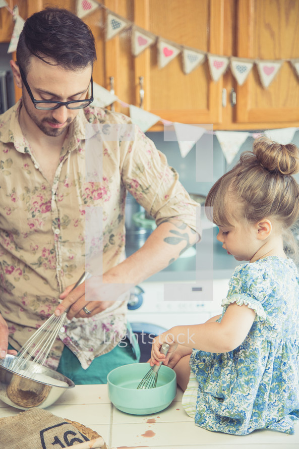 father and daughter baking in a kitchen 