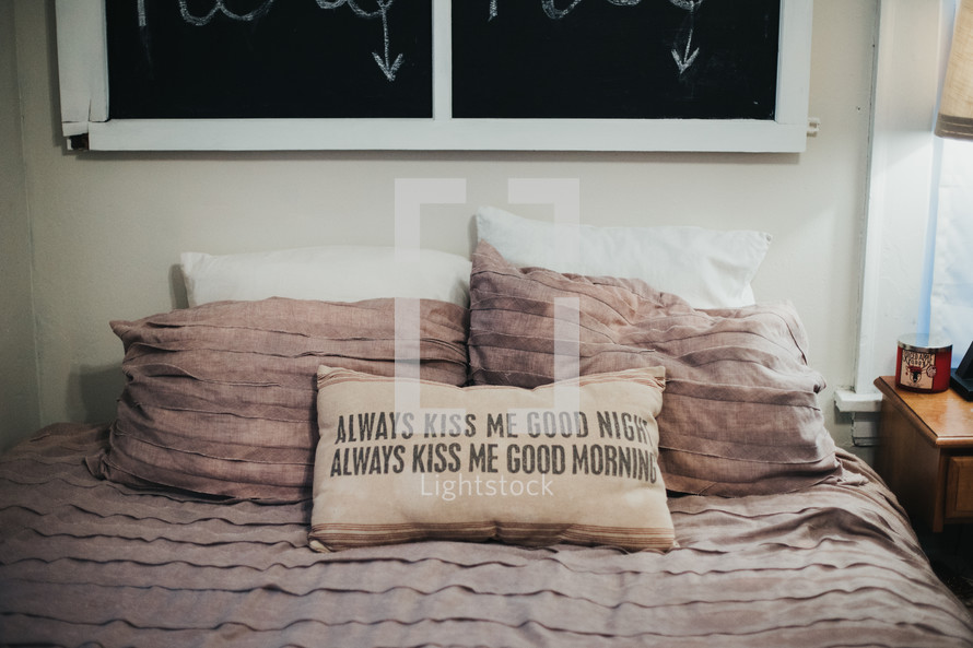 always kiss me good night, always kiss me good morning throw pillow on a bed 