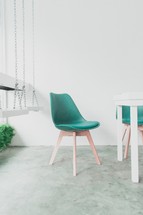 green chairs around a table and indoor swings 