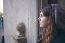 woman standing in a doorway wearing a wool cap 
