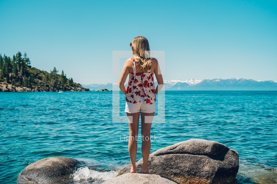 woman standing on a rock looking out at Lake Tahoe 