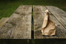 lunch sack on a picnic table 