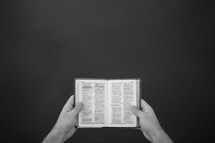 man holding a mini Bible 