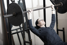 Businesswoman lifting weights 