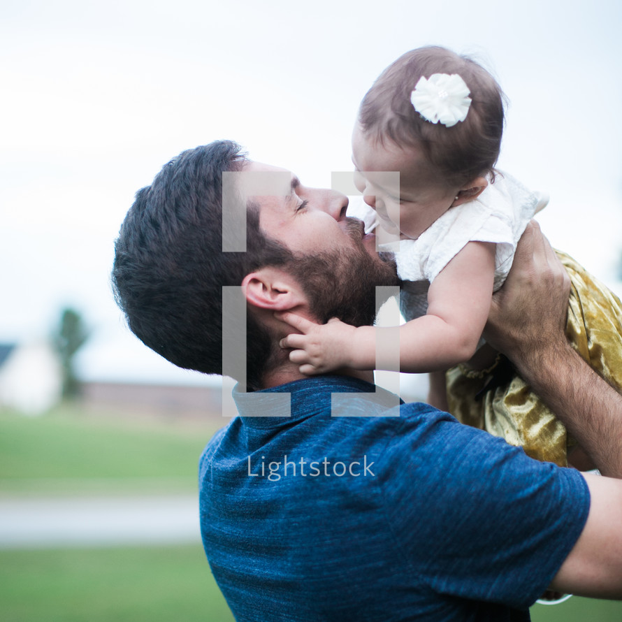 father kissing his toddler daughter 