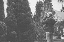 woman with a camera taking a picture outdoors 