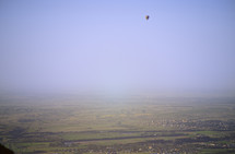 hot air balloon over a green valley 