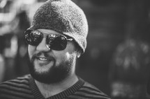 A man with a beard and sunglasses smiling
