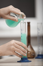 scientist pouring a liquid 