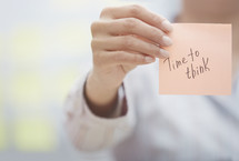 a woman holding a sticky note with the words time to think 