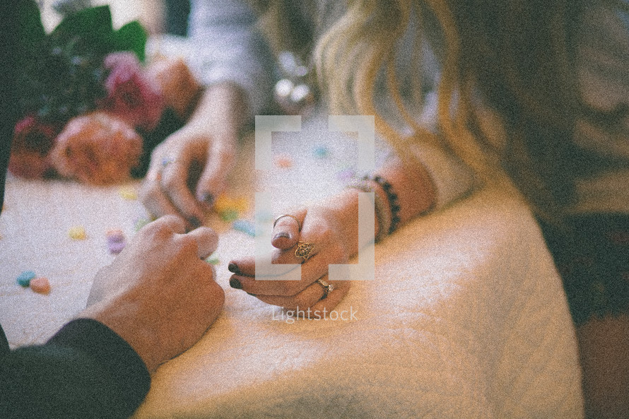couple holding hands and conversation hearts 