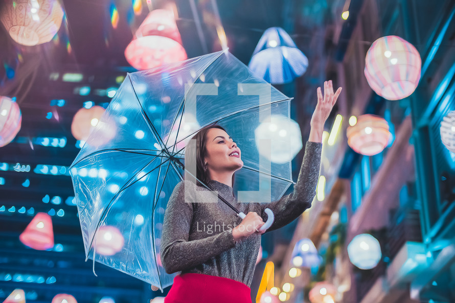 a woman carrying an umbrella at night in a city 