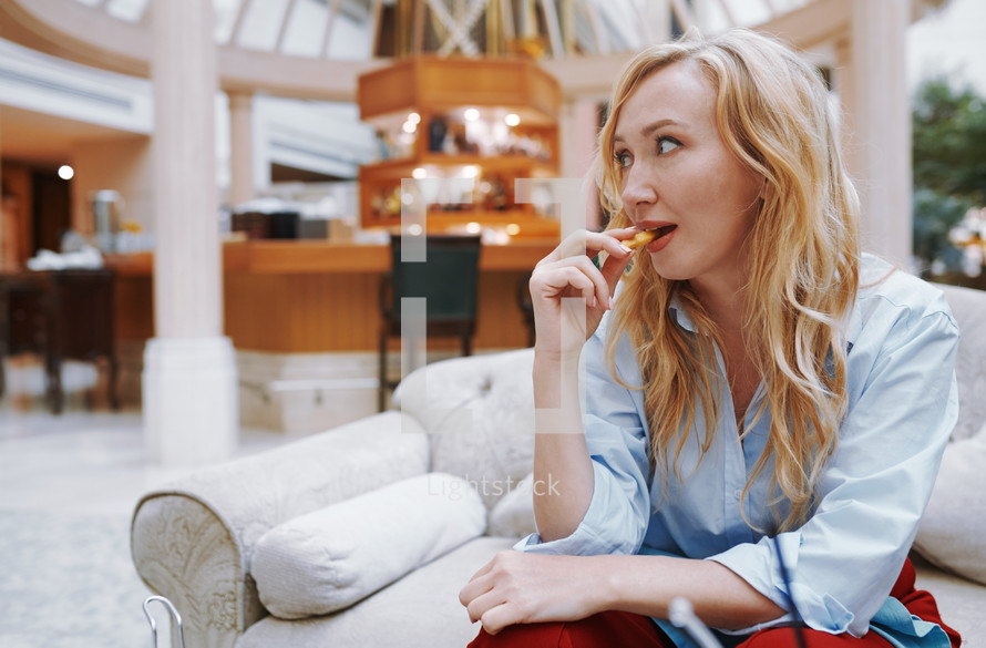 woman eating a snack in a hotel lobby 