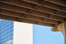 Low angle view of underneath a highway bridge and lower part of skyscraper